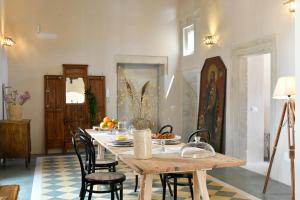 uma sala de jantar com uma mesa de madeira e cadeiras em Dimora Duchessina Suites de Charme em Minervino di Lecce