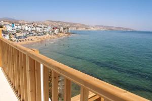 uma vista para a praia a partir de uma varanda em Aftas beach house em Taghazout