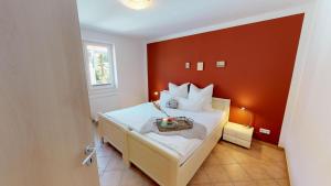 a bedroom with a bed with red walls at Feriendorf Südstrand Haus 09 in Pelzerhaken
