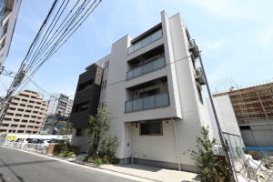 un edificio blanco al costado de una calle en GRAND BASE Hakata City, en Fukuoka