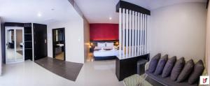 ein Schlafzimmer mit einem Bett und einem Sofa in einem Zimmer in der Unterkunft The Harbour Front Hotel in Surat Thani