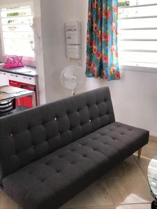 Sofá negro en una sala de estar con ventana en Bikamado en Deshaies