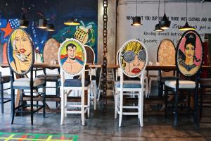 a row of chairs with portraits on them in a restaurant at The Henry Hotel Cebu in Cebu City