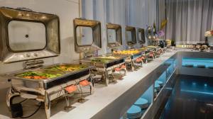 a row of trays of food on a buffet line at Paco Hotel Ouzhuang Metro Guangzhou in Guangzhou