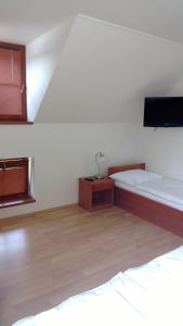 a bedroom with two beds and a tv on the wall at Pension Mlyn Stare Mitrovice in Prčíce