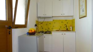 a kitchen with white cabinets and a sink at Seaside Cabin Ksamil in Ksamil +43 photos