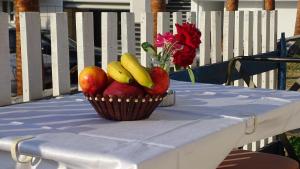 a basket of fruit on a table with a vase of flowers at Seaside Cabin Ksamil in Ksamil