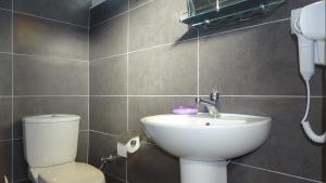 a bathroom with a white sink and a toilet at Seaside Cabin Ksamil in Ksamil