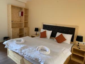 a bedroom with a large bed with two white towels on it at AMIGO LEH Guesthouse in Leh