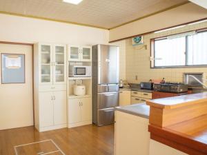 a kitchen with white cabinets and a stainless steel refrigerator at Guesthouse ENN in Gora