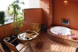 a hot tub on a deck with a table and chairs at ホテル イコイ in Kawaguchi