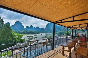 a balcony with a view of a river and mountains at Yangshuo Xingping This Old Place Li-River Inn in Yangshuo