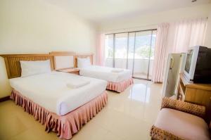 a hotel room with two beds and a television at Samerdrow Khao Yai in Mu Si