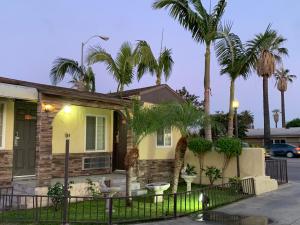 a house with palm trees in front of it at Apache Inn in Lynwood