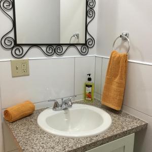 a bathroom sink with a mirror and a towel at Courage in Nassau