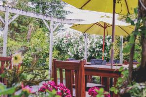 a wooden table with an umbrella and some flowers at Tongariro Crossing Lodge in National Park