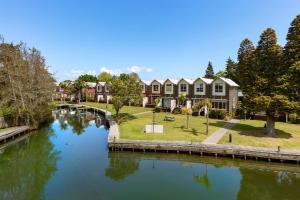 a river with a row of houses next to a canal at Ramada Resort By Wyndham Rotorua Marama in Rotorua
