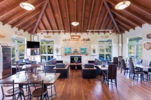 a large room with tables and chairs and a fireplace at Ramada Resort By Wyndham Rotorua Marama in Rotorua