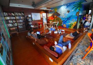 a group of people laying on couches in a library at Stay Malate (Wanderers Guest House) in Manila