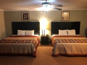 a hotel room with two beds and a ceiling fan at Global Inn in Coos Bay
