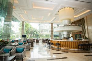 a lobby of a hotel with a bar and chairs at The Mira Central Park Hotel in Bien Hoa