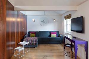 a living room with a blue couch and a tv at City Suites in London