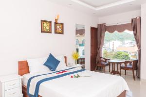 a bedroom with a bed and a table and a window at Kyo Hotel in Vung Tau