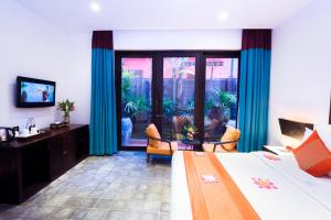 a hotel room with a bed and a television at Golden Temple Villa in Siem Reap