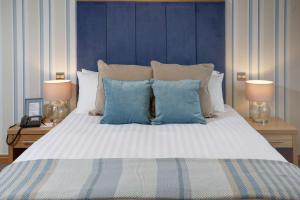 a bedroom with a large bed with blue walls at Best Western Princes Marine Hotel in Brighton & Hove