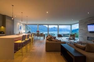 a living room and kitchen with a view of the mountains at Papillon, a Relax it's Done luxury holiday home in Queenstown