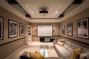 a living room with a couch and a screen at Papillon, a Relax it's Done luxury holiday home in Queenstown