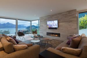 a living room with two couches and a fireplace at Papillon, a Relax it's Done luxury holiday home in Queenstown +24 photos