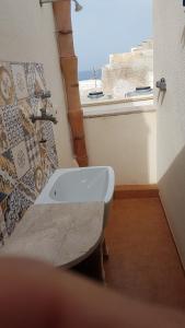 un bagno con lavandino e finestra di Cortile Via San Simone Marettimo a Marettimo