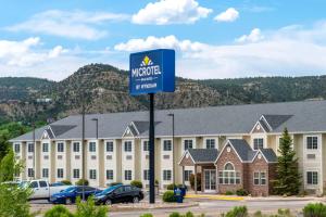 un panneau devant un grand bâtiment dans l'établissement Microtel Inn & Suites, à Raton