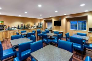 a dining room with tables and blue chairs at Microtel Inn & Suites in Raton