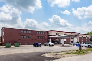 een groot bakstenen gebouw met auto's geparkeerd op een parkeerplaats bij Sleep Inn Terre Haute University Area in Terre Haute