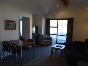 een woonkamer met een tafel en een bank bij Alpine Glacier Motel in Franz Josef