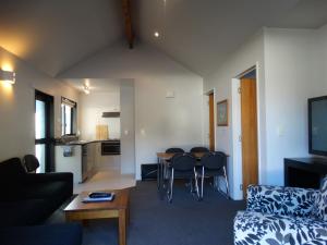 uma sala de estar com um sofá e uma mesa em Alpine Glacier Motel em Franz Josef