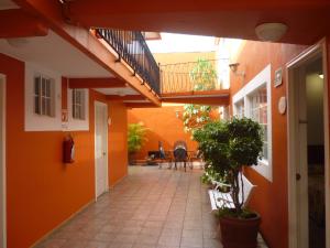un couloir vide aux murs orange et un balcon dans l'établissement Hotel Camba, à Oaxaca
