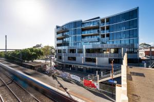 a tall building with a train in front of it at Anchorage Apartments Hampton in Melbourne