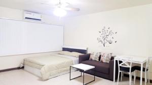 a bedroom with a bed and a couch and a table at Popular Condo C4 in Nonthaburi +10 photos