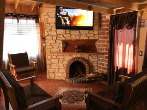 a living room with a fireplace with a tv on top at Hotel y Cabañas Alan in Chignahuapan
