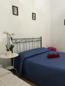 - une chambre avec un lit bleu et une table fleurie dans l'établissement Cinque terre SUITE, à La Spezia 2 autres photos
