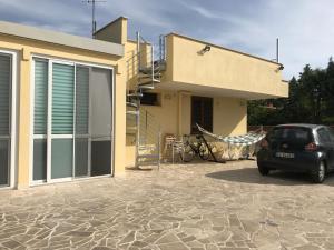 un'auto parcheggiata di fronte a una casa di B&B Sun House a Modugno