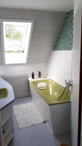 a bathroom with a green tub and a sink at FeWo Gabriela in Windhausen