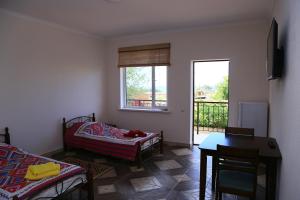 um quarto com uma cama, uma mesa e uma janela em Taj Altyn Hotel em Kaji-Say