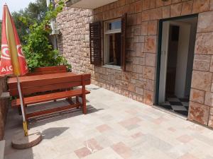 a wooden bench sitting next to a building with a flag at Zoro Apartments in Sveti Stefan