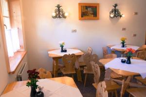 a dining room with tables and chairs with flowers on them at U Bohaca in Zakopane