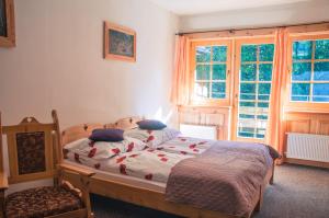 um quarto com uma cama, uma cadeira e janelas em U Bohaca em Zakopane