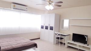 a bedroom with a bed and a desk and a television at Popular Condo C6 in Nonthaburi